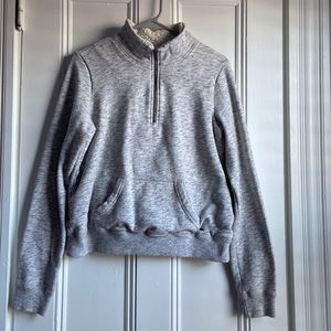 Light grey and white sweatshirt with a zipper and big pocket in the front